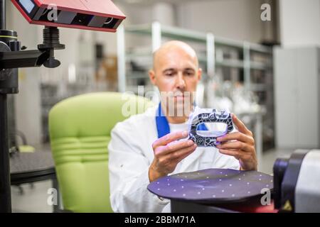 Tecnico di qualità che esegue la scansione di alcuni elementi stampati con scanner ottico 3D professionale, concetto automobilistico Foto Stock