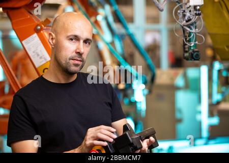 Ritratto di impiegato soddisfatto in fabbrica industriale intelligente, assunzione di nuovo dipendente a causa di crisi economica, concetto di industria Foto Stock