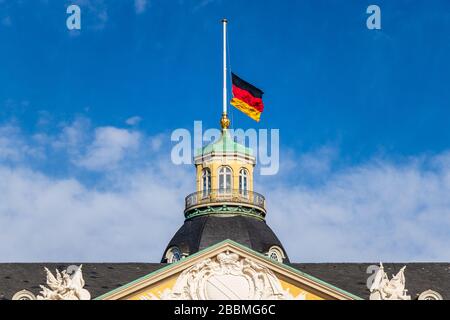 Vista ravvicinata sulla bandiera tedesca a Halfmast, auf Halbmast, sul tetto della torre del castello di Karlsruhe. Baden-Württemberg, Germania Foto Stock