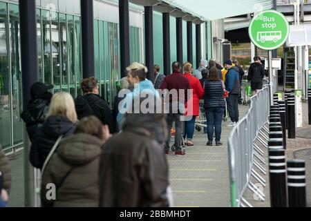 Hamilton, Scozia, Regno Unito. 1° aprile 2020. Lunga coda di acquirenti ad Asda ad Hamilton mantenendo raccomandato il coronavirus sociale distanziamento. Iain Masterton/Alamy Live News Foto Stock