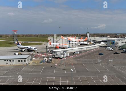 Gli aerei Ryanair e esayJet parcheggiati vicino a un parcheggio vuoto per soggiorni prolungati all'aeroporto di Southend dopo che le compagnie aeree hanno ridotto i voli in mezzo a restrizioni di viaggio e un enorme calo della domanda a causa della pandemia di coronavirus. Foto Stock