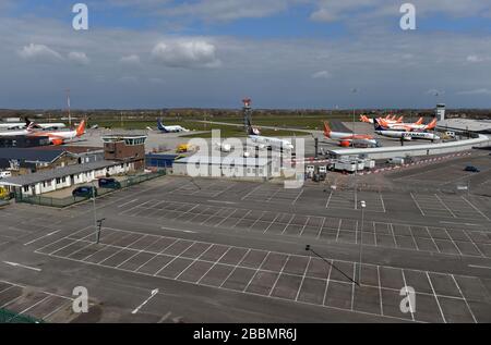 Gli aerei Ryanair e esayJet parcheggiati vicino a un parcheggio vuoto per soggiorni prolungati all'aeroporto di Southend dopo che le compagnie aeree hanno ridotto i voli in mezzo a restrizioni di viaggio e un enorme calo della domanda a causa della pandemia di coronavirus. Foto Stock