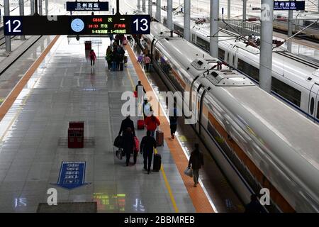 (200401) -- LANZHOU, 1 aprile 2020 (Xinhua) -- i passeggeri si preparano a salire a bordo di un treno per Guangzhou alla Stazione ferroviaria Ovest di Lanzhou a Lanzhou, nella provincia di Gansu della Cina nord-occidentale, 1 aprile 2020. Il servizio ferroviario da Lanzhou a Guangzhou, Shanghai, Wuhan e Urumqi è gradualmente ripreso con rigide misure di prevenzione del coronavirus. (Cestino di Xinhua/Chen) Foto Stock