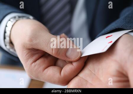 Uomo di closeup in vestito che nasconde la carta di asso nella manica Foto Stock