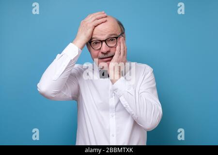 uomo che guarda caemra perplesso e pensando di non avere idea cosa fare Foto Stock