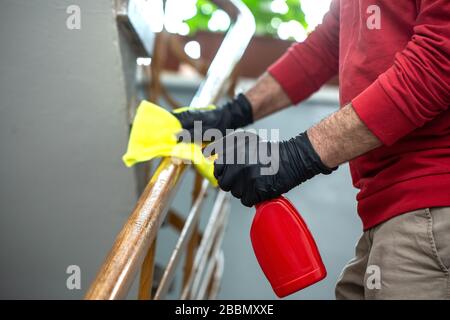 Prevenzione pandemica del coronavirus. Pulizia profonda per l'alcool della malattia di Covid-19, spray disinfettante sulla maniglia della porta a casa Foto Stock