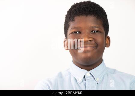 Testa e spalle Studio Ritratto di Smiling Boy contro sfondo bianco Foto Stock