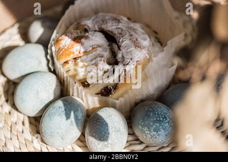Torta di Pasqua e uova pastello colorate sullo sfondo di tovagliolo di rattan. Belle uova blu chiaro. Sfondo di Pasqua. Felice concetto di Pasqua. Uova trush. Foto Stock