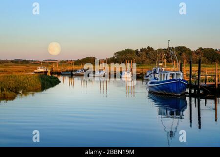 Luna che sorge sopra casa barca a Thornham, Norfolk, Inghilterra Foto Stock