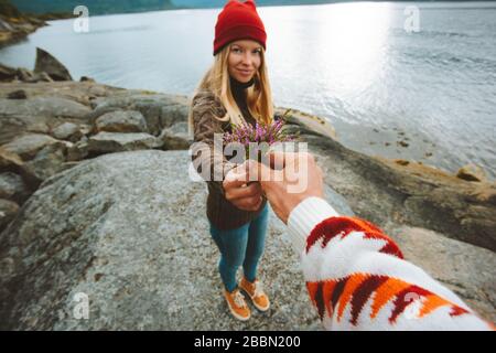 Mano che dà fiori alla coppia fidanzata romantica datazione all'aperto rapporto vacanze stile di vita amore concetto uomo e donna a piedi sul mare Foto Stock