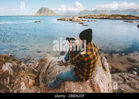 Uomo viaggio blogger fotografo con fotocamera sulla spiaggia influenzatore stile di vita hobby avventura estate vacanza viaggio all'aperto Foto Stock