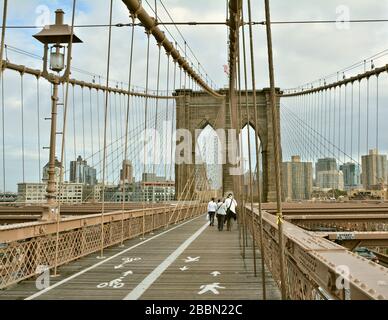 NEW YORK CITY - 15 OTTOBRE 2014: La gente cammina sul ponte di Brooklyn. Il Ponte di Brooklyn collega i quartieri di Manhattan e Brooklyn sul Fiume Est Foto Stock