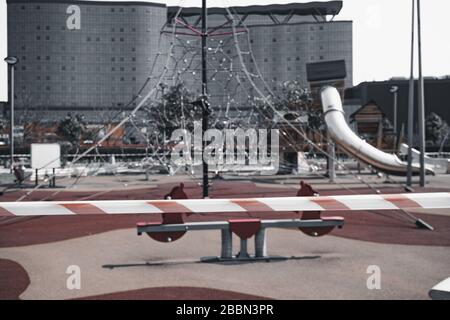 Il parco giochi nel parco è circondato da un nastro di divieto di avvertimento durante la quarantena per proteggere contro la diffusione del COVID-19 coronavirus epi Foto Stock