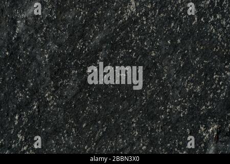 Muro di pietra con tonalità grigio scuro e bianco. Foto dettagliata di una pietra bianca e nera e di una texture rocciosa naturale. Foto Stock