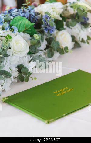 fiori e registro libro sul tavolo Foto Stock