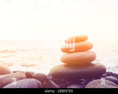 Equilibrio, tranquillità, diverse dimensioni pietre formano una piramide, pietre piramide sulla spiaggia di ghiaia simboleggia stabilità, zen, armonia, equilibrio. Bassa de Foto Stock