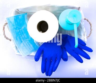 Foto di un Novel Coronavirus Covid-19 Confezione regalo in un cesto rotolo di carta igienica maschera medica viso guanti Latex igienizzatore a mano cesto bianco su sfondo bianco Foto Stock