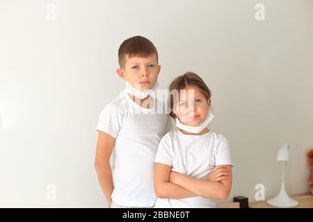 I bambini in una maschera respiratoria si trovano in quarantena a casa Foto Stock