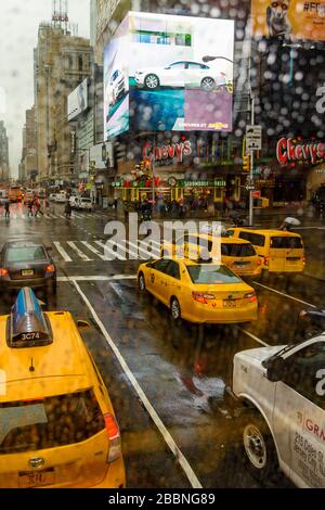 New York Taxis visto in una giornata di pioggia allo 5th Avenue e West 42nd Street a New York Foto Stock