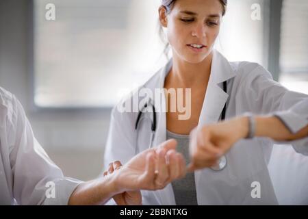 Un medico sta controllando il polso di un uomo. Foto Stock