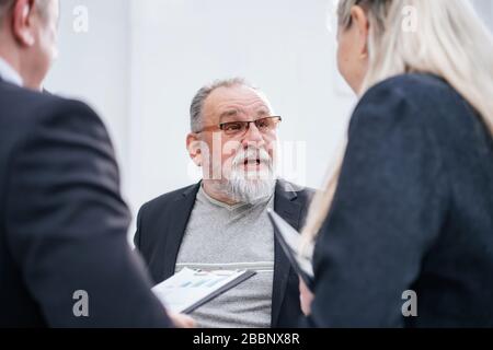 capo e gruppo di lavoro che discutono i documenti finanziari Foto Stock