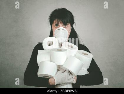 Giovane donna pazzo che afferra rotoli di carta igienica. Follia causata dalla crisi sanitaria del coronavirus Foto Stock