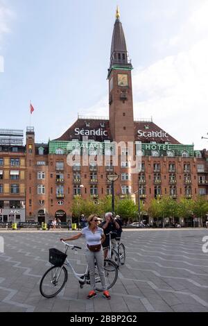 Persone con biciclette sulla Rådhuspladsen con lo Scandic Palace Hotel sullo sfondo, Copenaghen, Danimarca, Europa Foto Stock