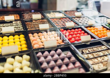 Assortimento di dolci caramelle sulla vetrina caffè. Varietà di dolci con diversi sapori noci spezie in negozio. Foto Stock