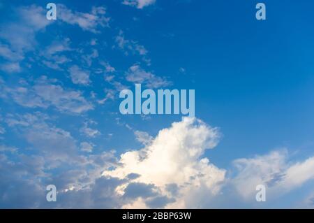 Cielo blu con nuvole bianche al sole in una serata estiva Foto Stock