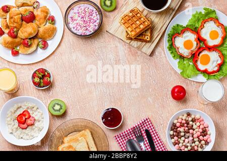 Colazione continentale con cereali, uova fritte, croissant, frutta e bevande sul tavolo testurizzato Foto Stock