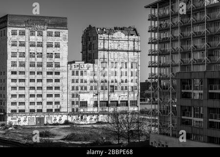 Rigenerazione. Spillers derelict turno del millennio Mills secolo attendono ristrutturazione, mentre nuovi appartamenti di costruzione primavera di fronte. Foto Stock