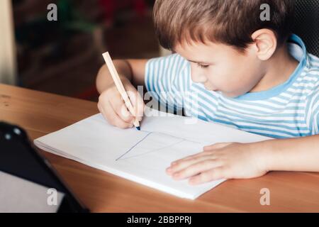 Modern Child utilizza app sul tablet per studiare e disegnare a casa, imparare a distanza Foto Stock