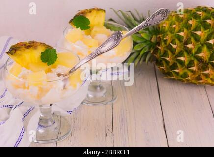 Gelato all'ananas in una ciotola di vetro su sfondo bianco. Foto Stock