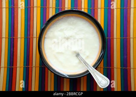 Yogurt greco in una ciotola di legno su un rustico tavolo di legno. Foto Stock