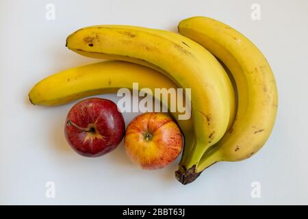 mele e banane con spazio copia e sfondo bianco Foto Stock