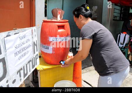 Jakarta, Indonesia. 1st Apr, 2020. Controlli di serraggio presso gli ingressi residenziali, check-in e check-out dei residenti da parte degli ospiti mediante spray disinfettanti e sono necessari per lavarsi le mani a Pegangsaan Dua. I residenti che si autoaiutano a stringere l'esame all'ingresso della loro residenza mirano a rompere la catena di diffusione del COVID-19, a seguito dell'aumento dei pazienti positivi nella zona di Giacarta. Credit: Dasril Roszandi/ZUMA Wire/Alamy Live News Foto Stock