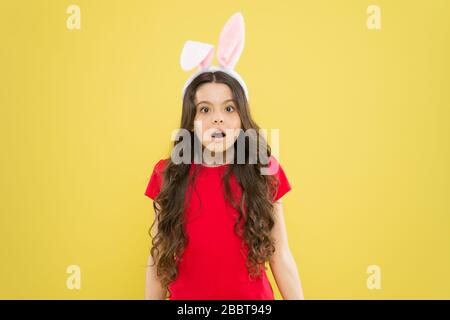 Sei pronto a festeggiare. Capretto sulla caccia all'uovo di Pasqua. Ragazzino in costume di coniglio che si divertono. buona pasqua. Bambina che indossa orecchie di coniglio. Sorpresa bambino in costume. Coniglio di Pasqua con orecchie. Foto Stock