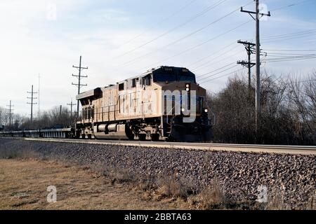 Ginevra, Illinois, Stati Uniti. Una singola locomotiva che conduce una serie di pile vuote o di container merci auto in un treno nel suo viaggio verso est a Chicago. Th Foto Stock