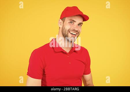 Amichevole negozio assistente. food order deliveryman. cassiere vacante. Affitto shop store lavoratore. happy guy. concessionario parete gialla. Venditore cassiere carriera. l uomo servizio consegna in rosso tshirt e tappo. Foto Stock