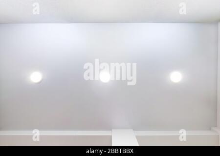 soffitto sospeso con lampade led e costruzione di cartongesso in camera vuota in appartamento o casa. Soffitto stretch bianco e forma complessa. Look Foto Stock