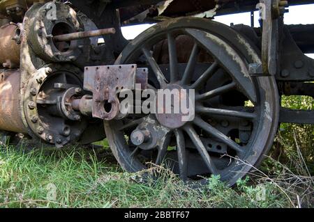 Vecchia locomotiva a vapore della ferrovia disfunzionale che è overgrown con erbacce. Foto Stock