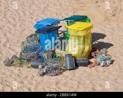 Separazione dei rifiuti in una spiaggia con trappole per pesci Foto Stock