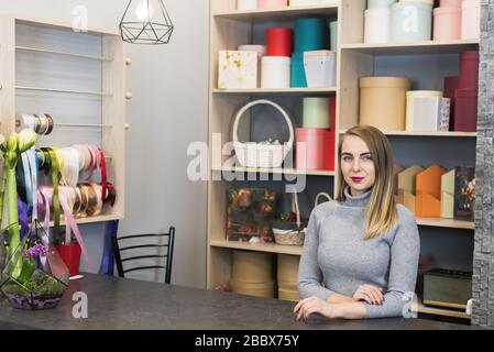 Donna fiorista si trova alla reception in un negozio di fiori. Rappresentante delle piccole imprese. Foto Stock