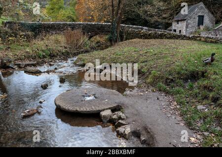 Un vecchio mulino situato nel fiume dove a Viators Bridge, villaggio di Milldale, Peak District National Park, Inghilterra, Regno Unito Foto Stock