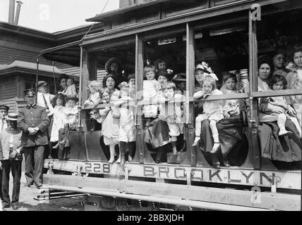 Madri e loro figli in trolley car che si dirigono al traghetto che li ha portato a Sea Breeze, Coney Island, in un viaggio sponsorizzato dalla Fresh Air Home della New York Association per migliorare le condizioni dei poveri Foto Stock