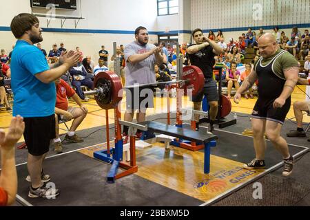 Salutato con applausi dal pubblico e dal personale, un agente di pattuglia di confine di Bonners Ferry Idaho, con un'occhiata di determinazione, significa business, mentre si avvicina alla panchina per la sua panchina del record mondiale di 551lbs alla polizia mondiale e ai Giochi antincendio di Herndon Virginia. Foto Stock