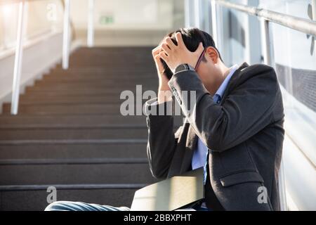 L'uomo d'affari ha perso nella depressione che grida sedendosi sulle scale della strada del terreno che soffrono la tristezza impressionabile di dolore. Disoccupati senza lavoro crisi persone che sottolineano un Foto Stock