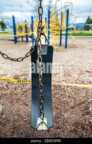 Surrey, Canada - 29 marzo 2020: Altalene e parco giochi chiusi a causa della pandemia di Coronavirus Covid-19 Foto Stock