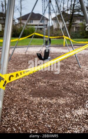 Surrey, Canada - 29 marzo 2020: Altalene e parco giochi chiusi a causa della pandemia di Coronavirus Covid-19 Foto Stock