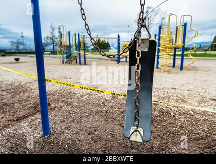 Surrey, Canada - 29 marzo 2020: Altalene e parco giochi chiusi a causa della pandemia di Coronavirus Covid-19 Foto Stock